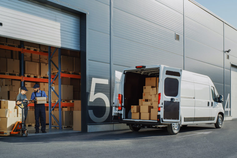 Blog header image showing a courier van being loaded by warehouse staff