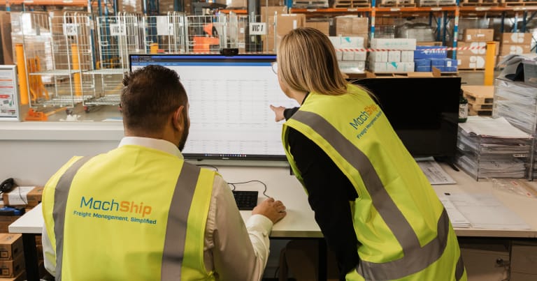 freight broker with a Machship vest using a device looking at rate cards in a PC