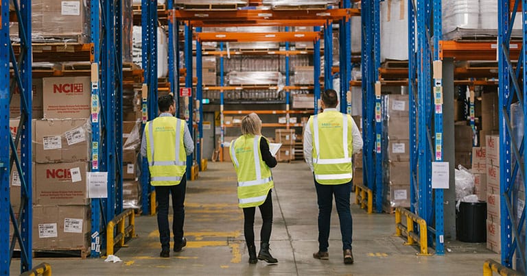 Warehouse workers with a device in use