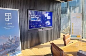 Conference room setup showing Fenwick and MachShip banners and a presentation screen displaying the title ‘Scaling Smarter: How to Keep Shipping Simple While You Grow,’ highlighting the partnership between Fenwick Apps and MachShip.