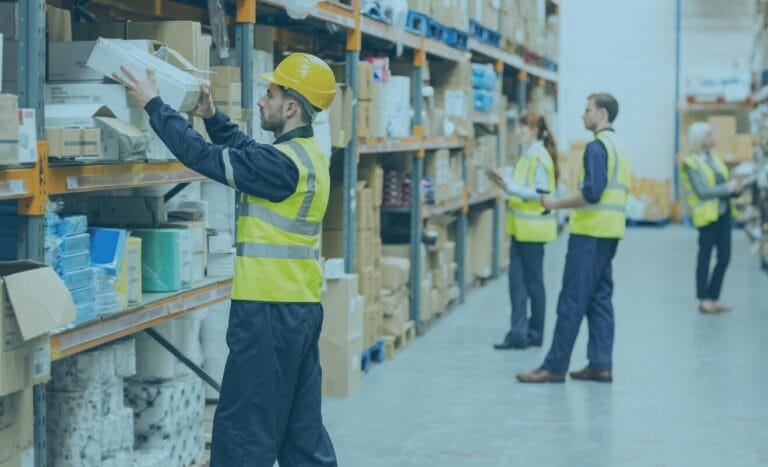 Warehouse workers in safety vests organising shelves for improved freight efficiency.