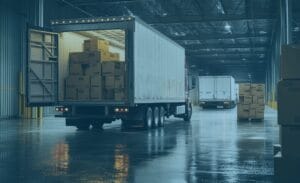 A truck is being loaded with boxes in a multi-carrier environment within a large warehouse.